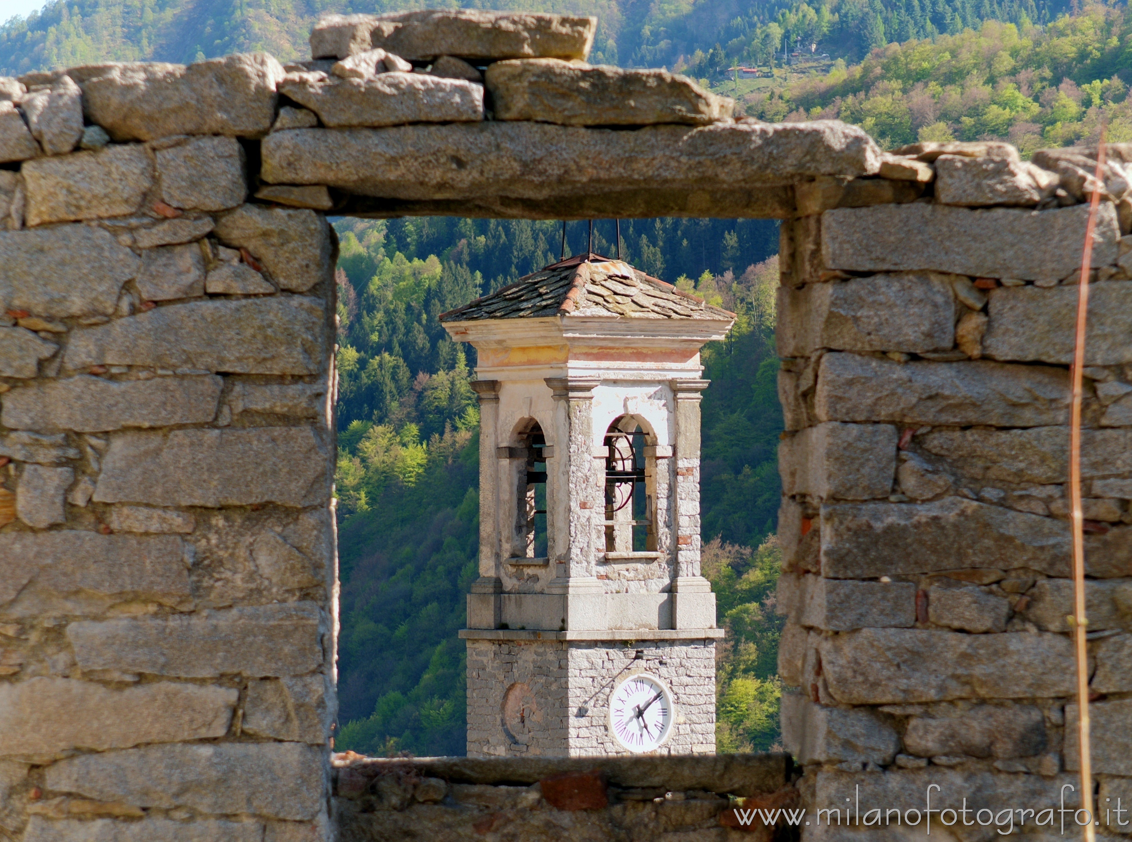 Campiglia Cervo (Biella, Italy) - Bell tower of the Oratory of the Saints Sebastian and Fabian from behind a stone wall